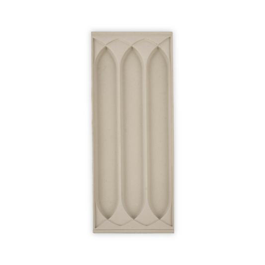 A stone tray with a three gothic arch patterns for putting writing supplies in.