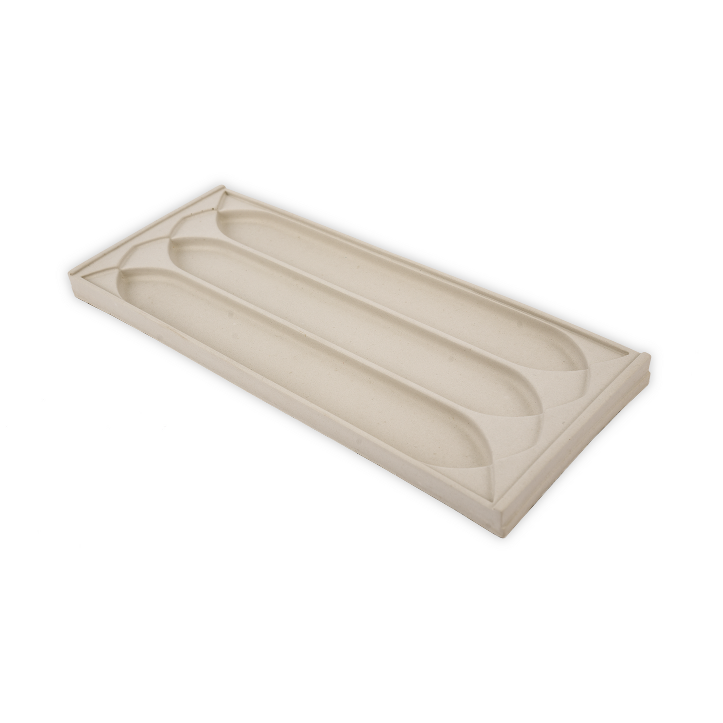 A stone tray with a three gothic arch patterns for putting writing supplies in.
