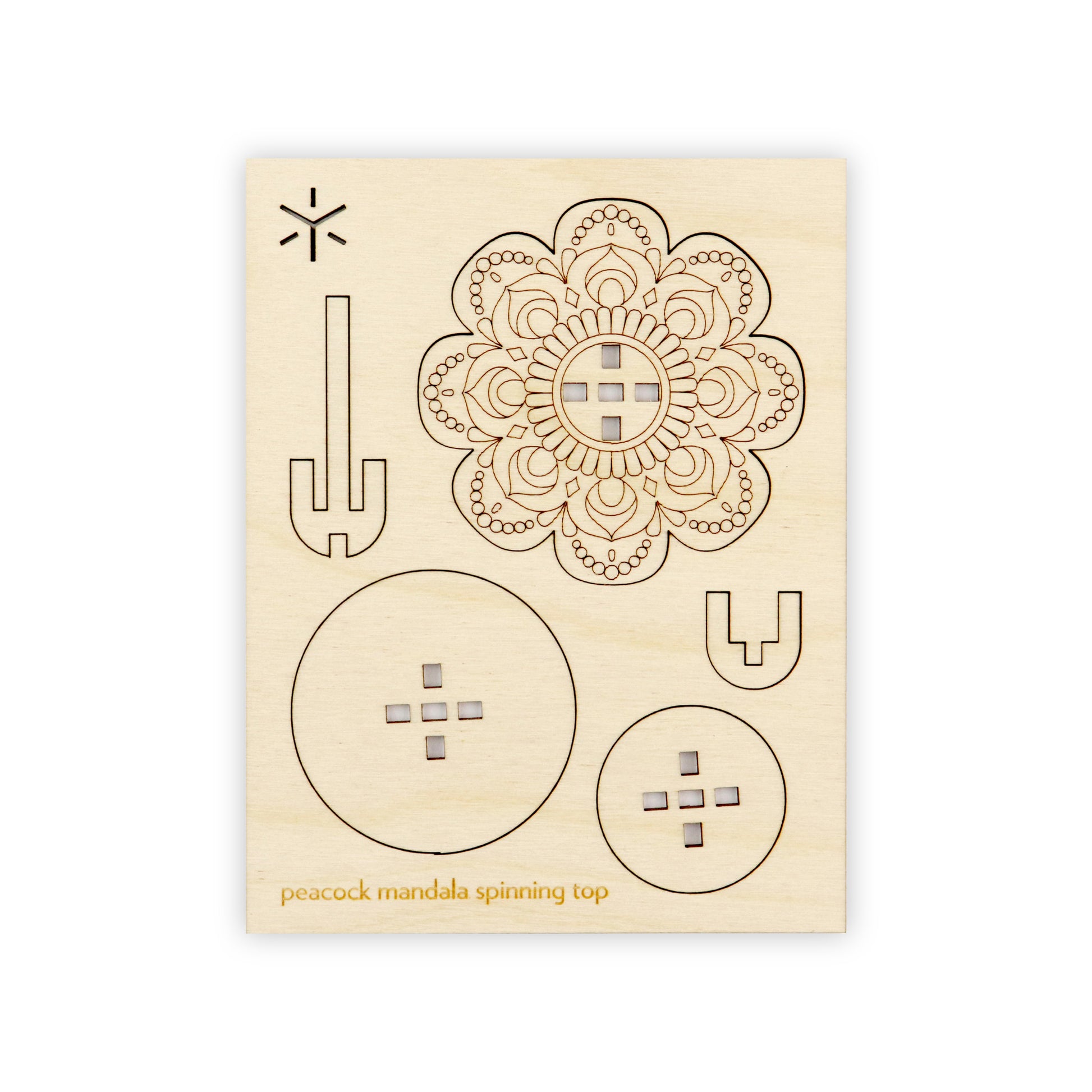 A flat wooden board with several removable shapes cut into it. On the bottom of the wooden board is written in yellow "peacock mandala spinning top".
