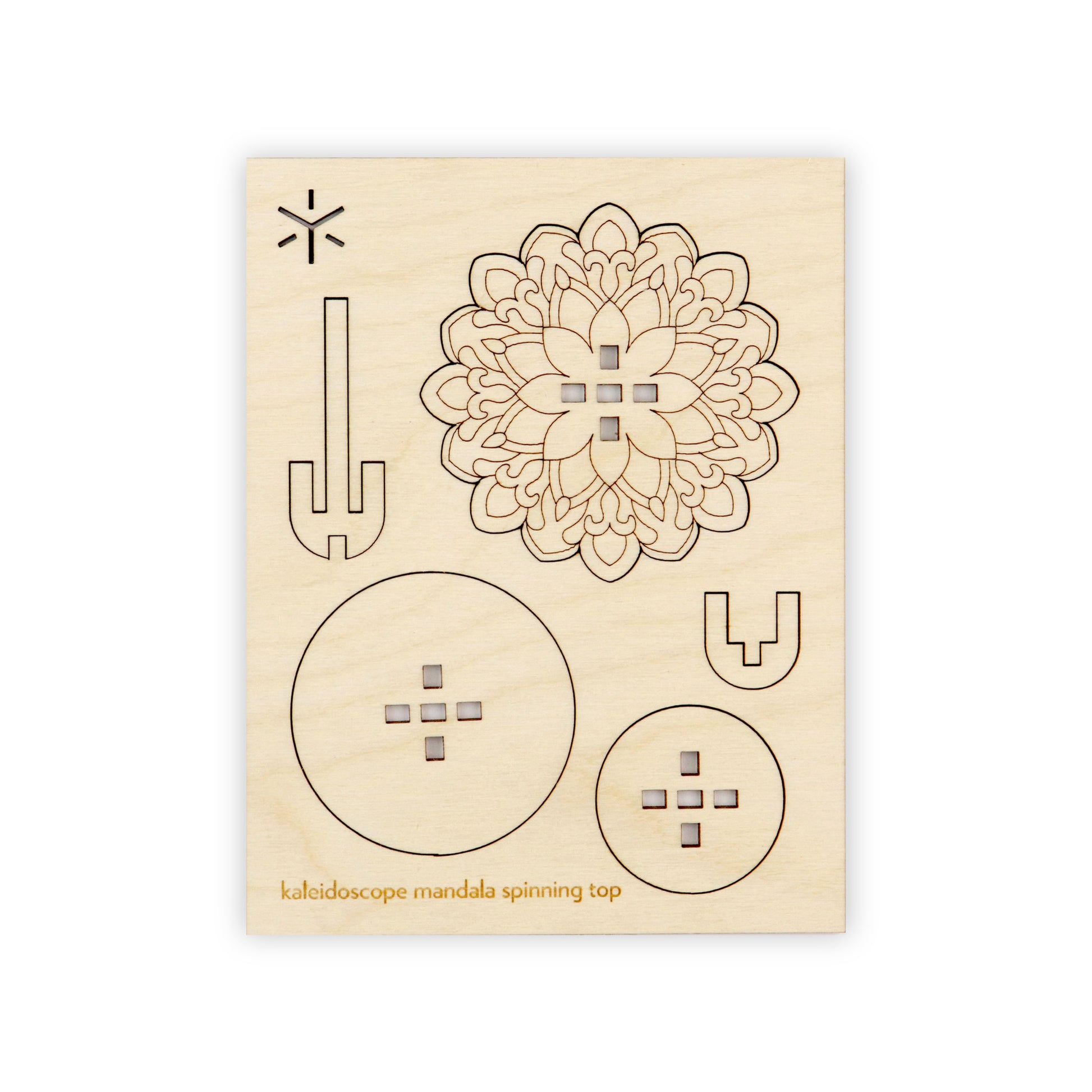 A flat wooden board with several removable shapes cut into it. On the bottom of the wooden board is written in yellow "peacock mandala spinning top".